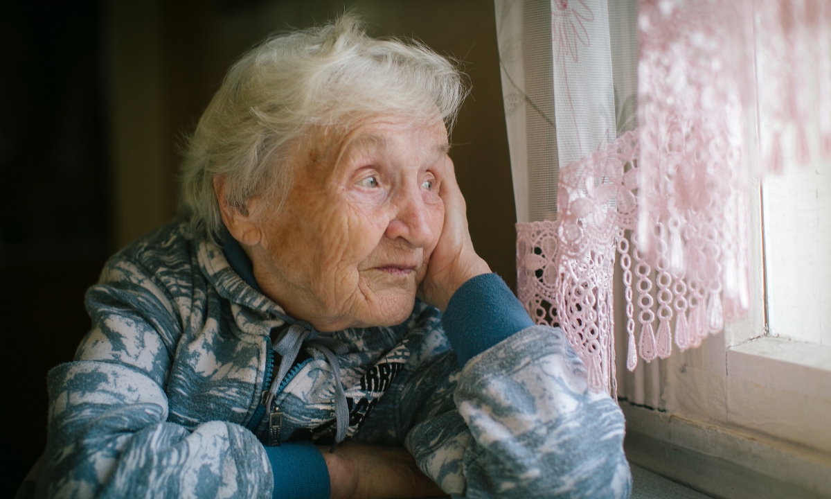 an elderly woman looking out the window
