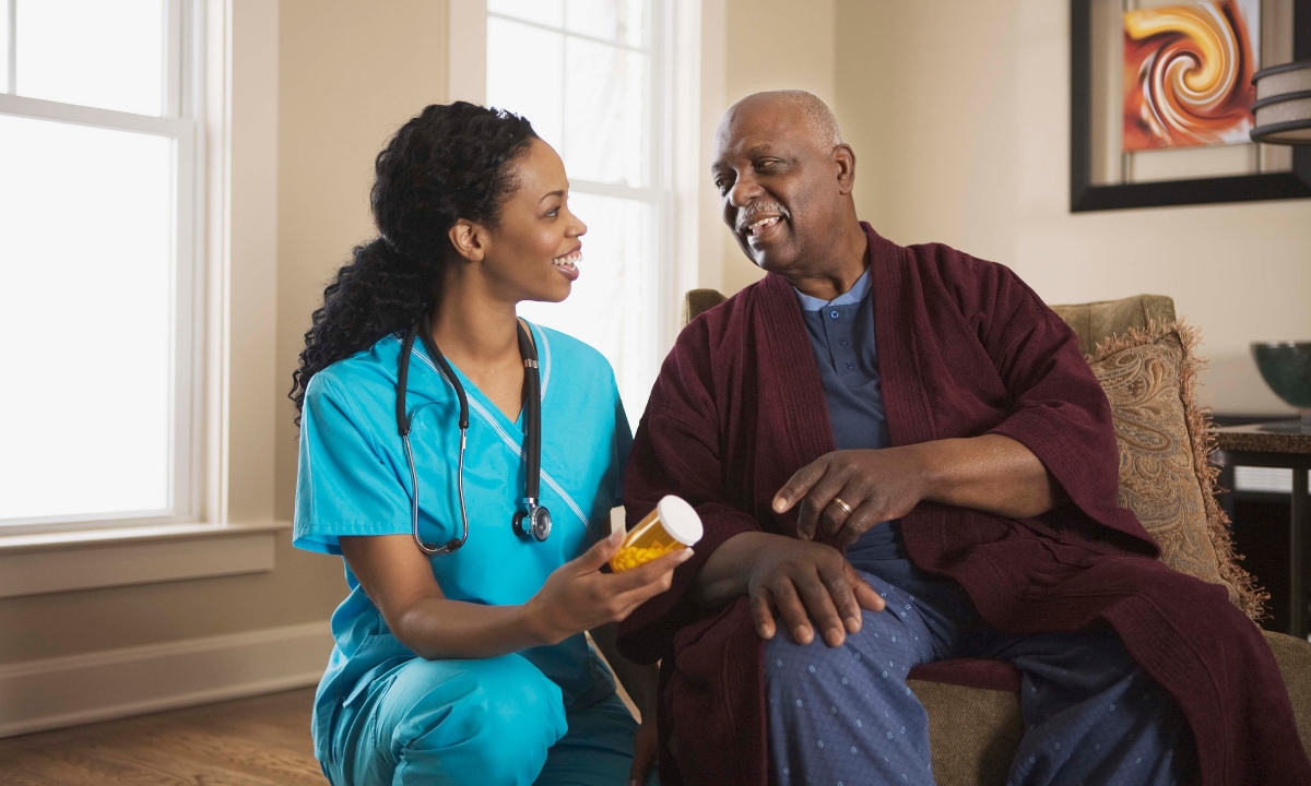 a nurse holding a medicine bottle and smiling at her patient