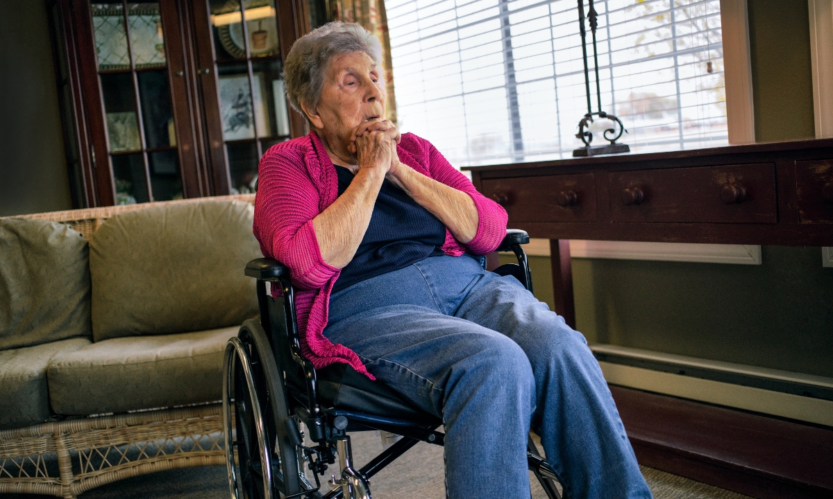an elderly woman in a wheelchair looks frightened