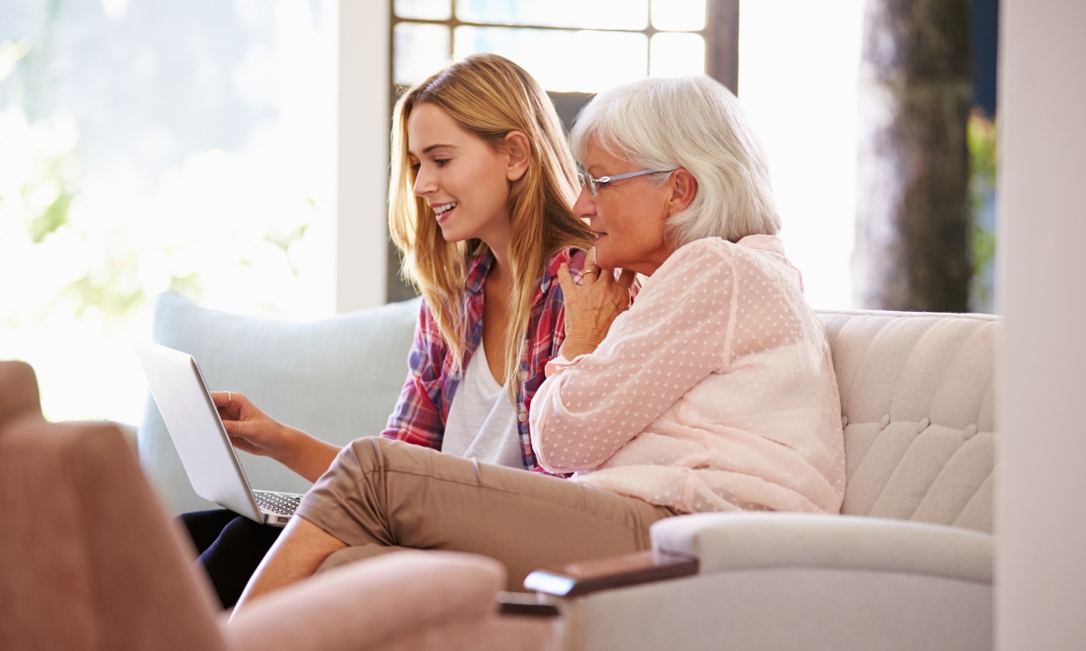 a woman sitting on a couch conversing with her mother