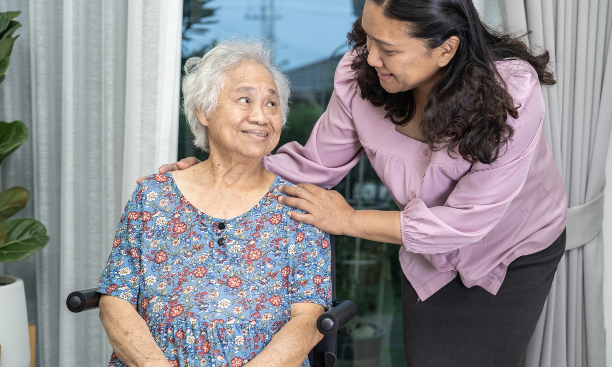 an elderly woman smiling at her daughter