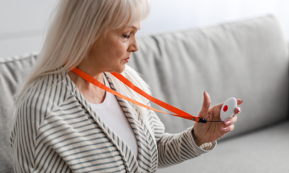 a senior woman wearing a medical alert system around her neck