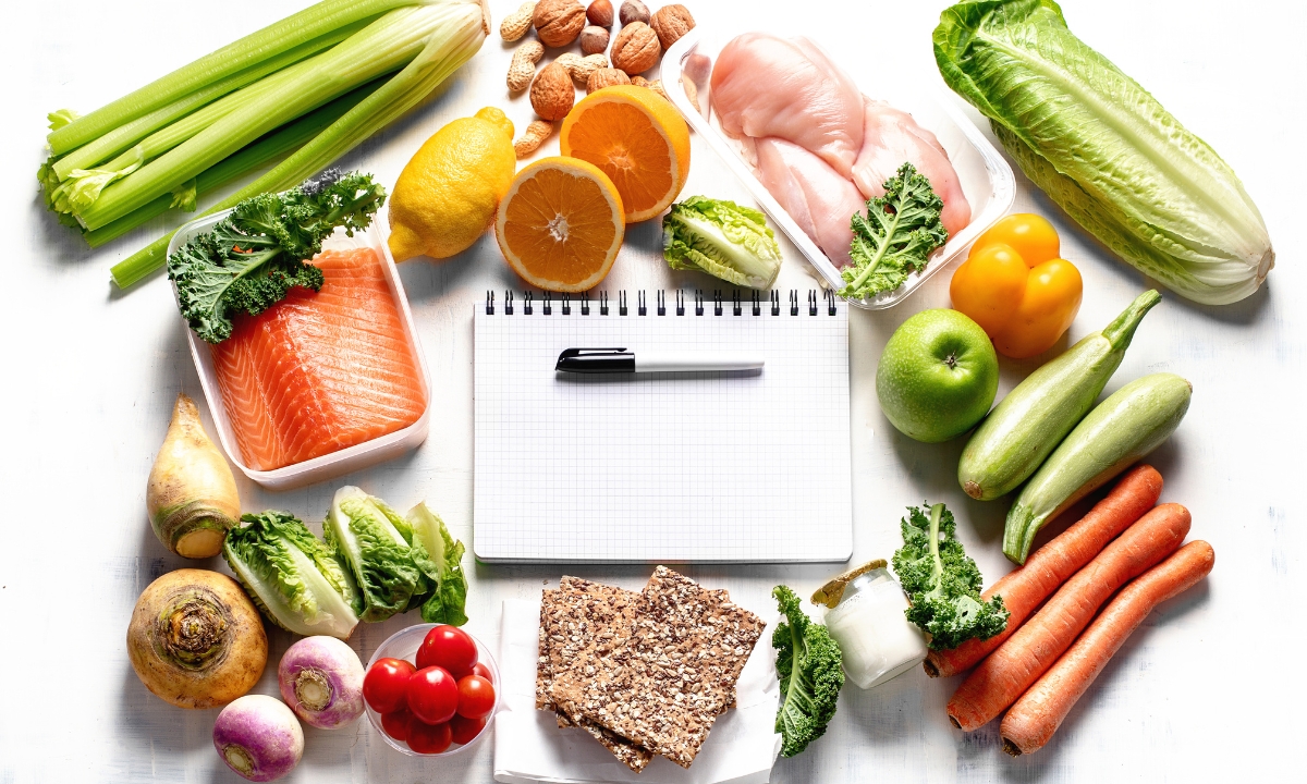 a bunch of healthy food laid out around a planner