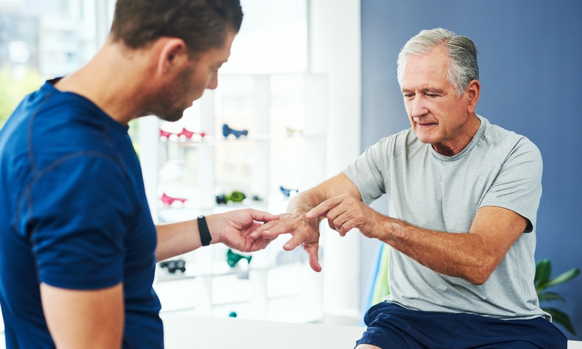 an elderly man showing his doctor his elbow