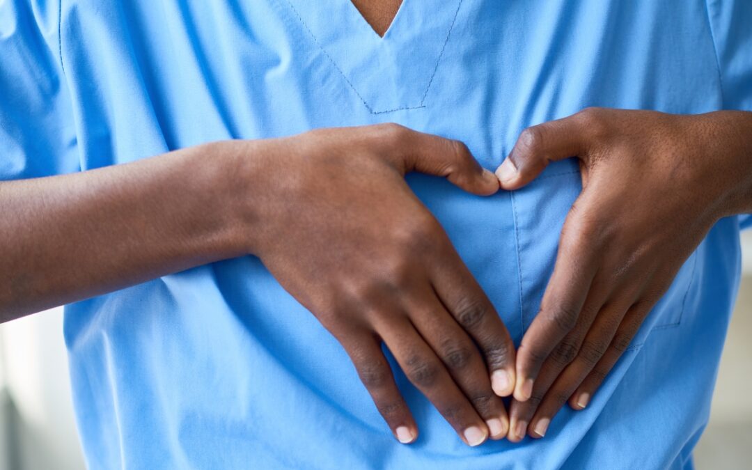 a person's hands in the shape of a heart over the left side of their chest