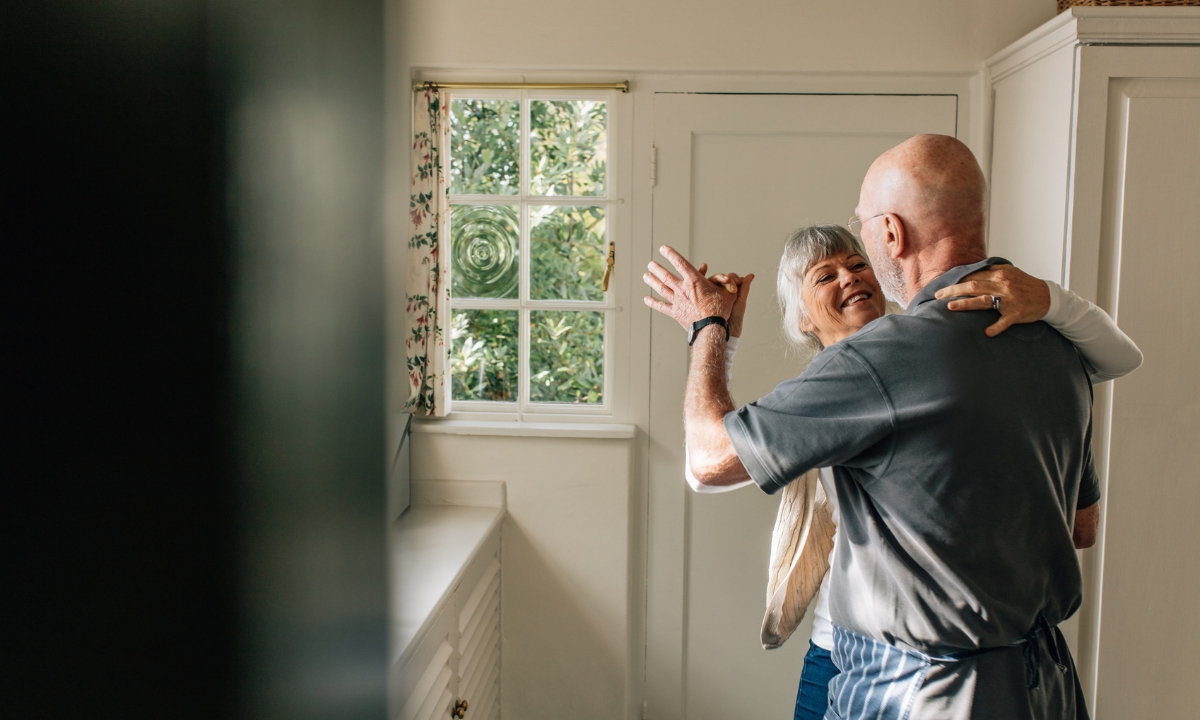 a senior couple dancing in their laundry room