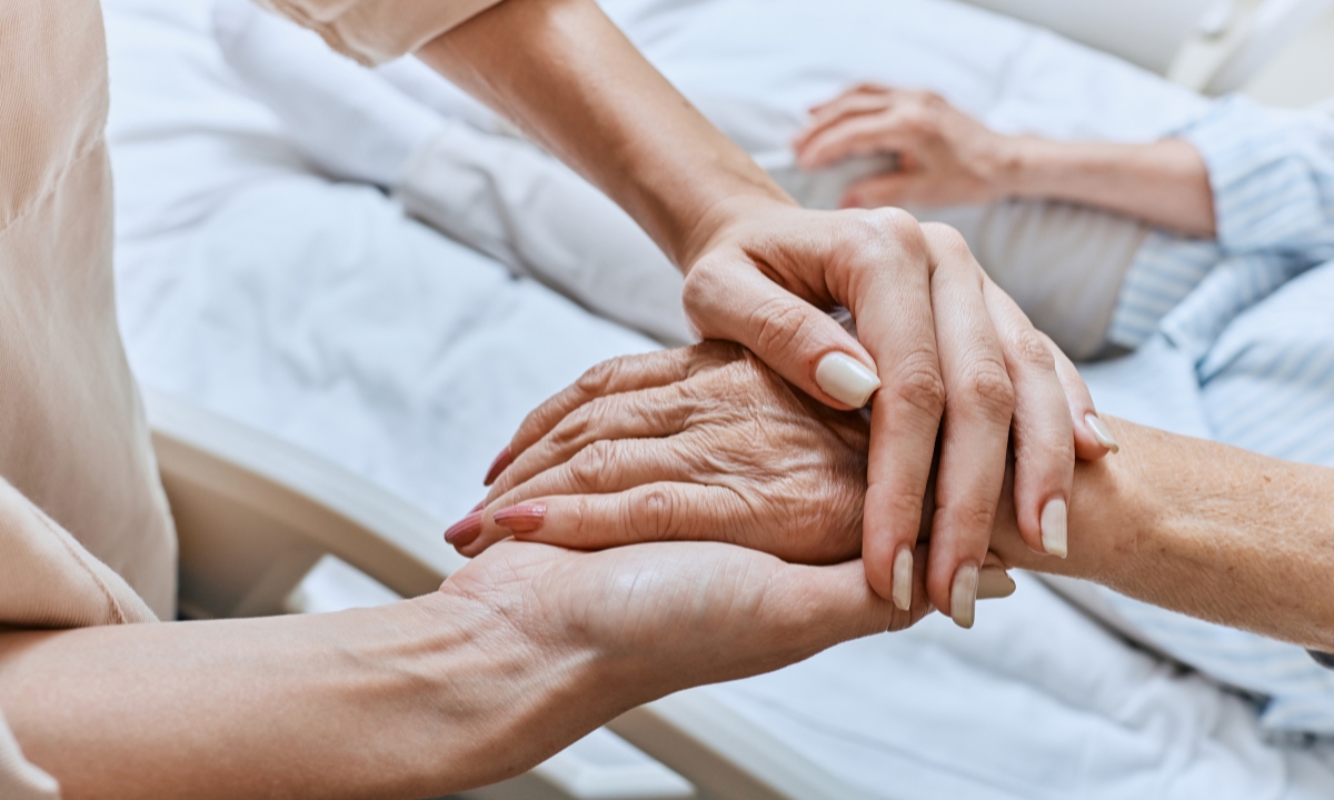 a senior's hand in a younger person's hands