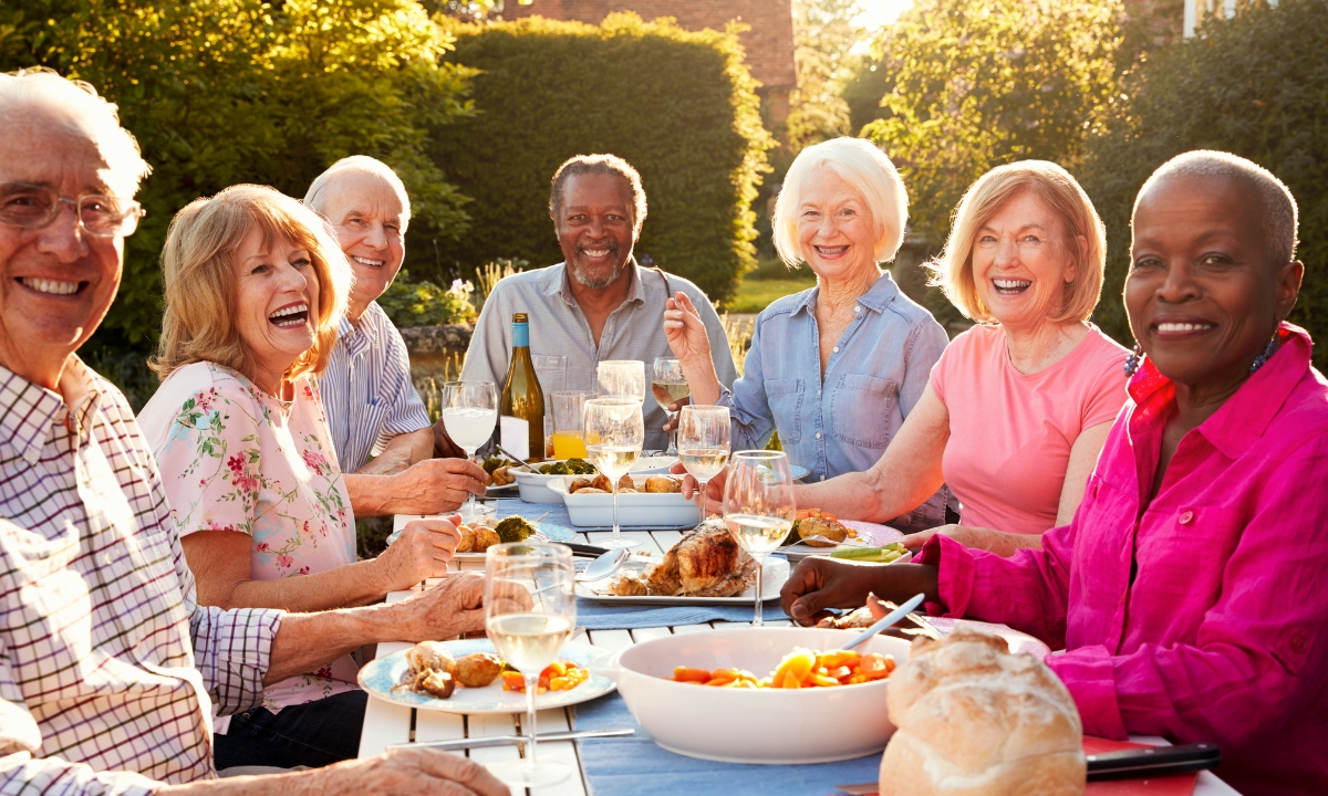 a group of seniors around a table full of food