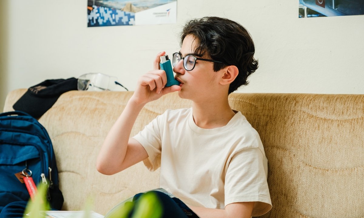 a child on a couch using an inhaler