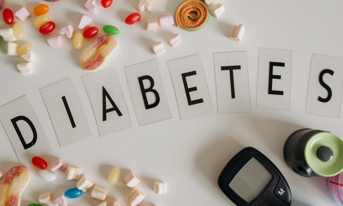 plastic letters that spell out "diabetes", surrounded by candy and blood sugar monitors