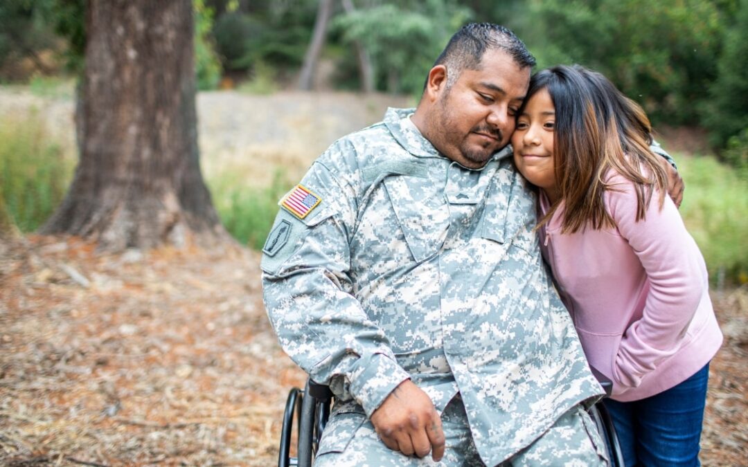an Army veteran in a wheelchair nuzzling with his daughter